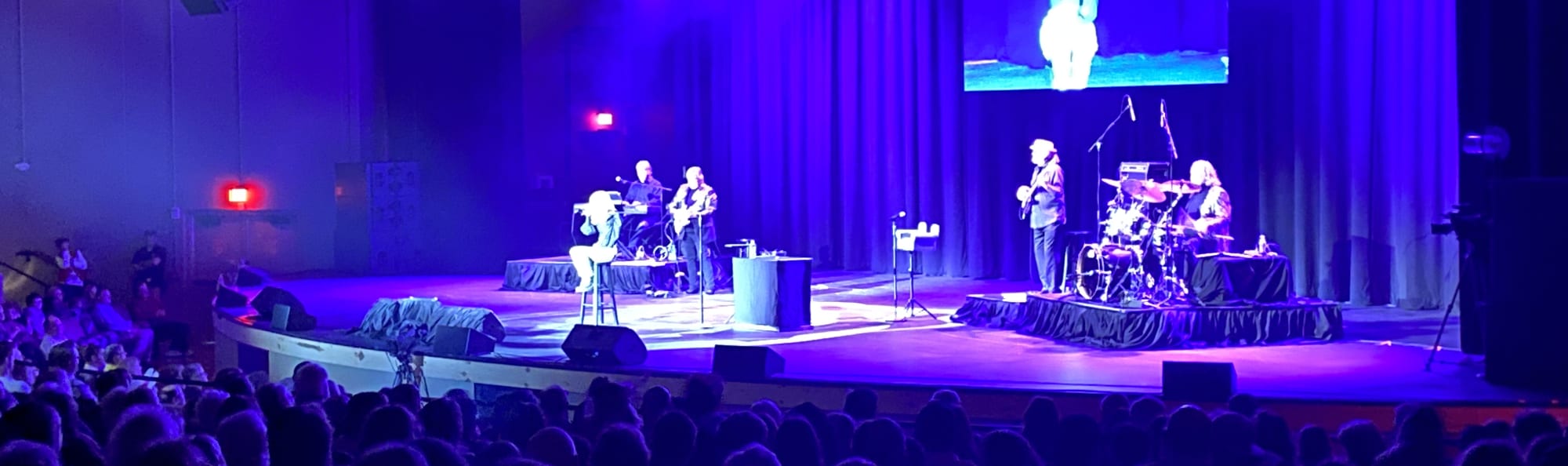 signer on stage in chair washed out by the lights Portland